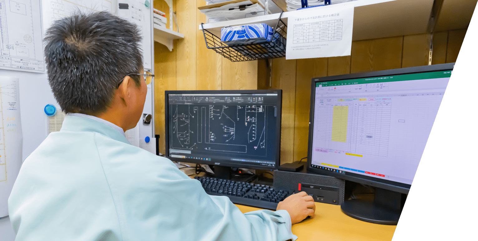 新栄電機株式会社の社員がコンピュータ画面を見ながら設計図を作成している様子